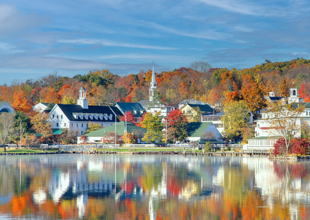 Town with colorful autumn foliage reflected in a lake